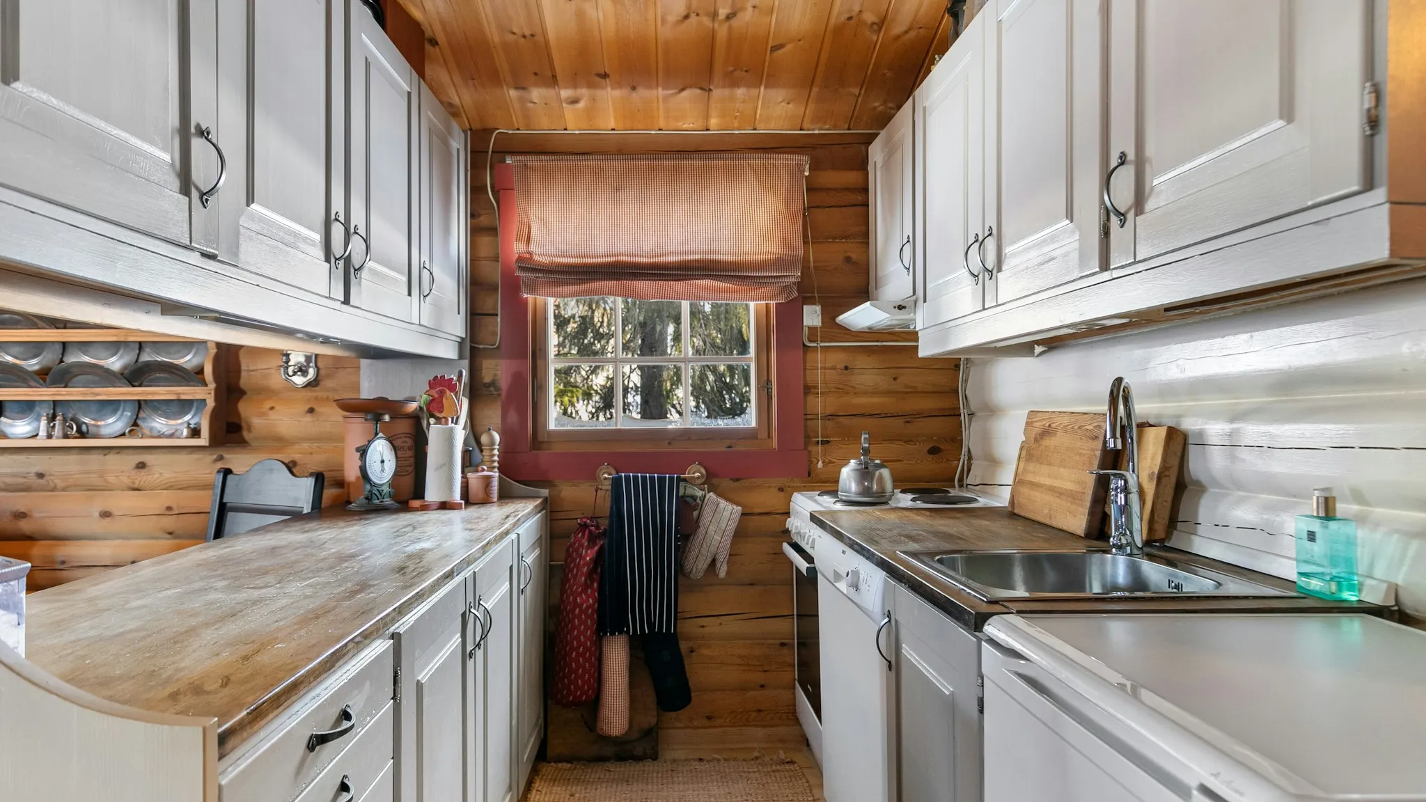 Modern farmhouse kitchen with white shaker cabinets, wood beams, and a farmhouse sink in a San Diego home